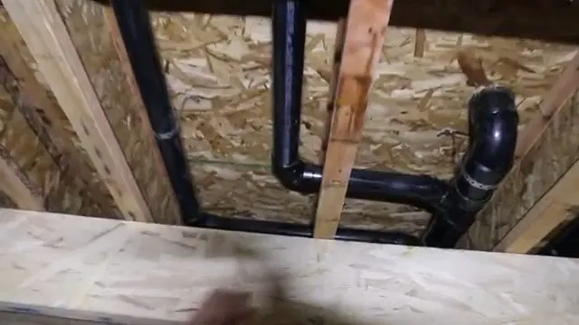 Black PVC Basement Drain Rough In Between Joists shown for Is a Slow Drain an Emergency on a Dallas, GA Septic System? in Dallas, Georgia.