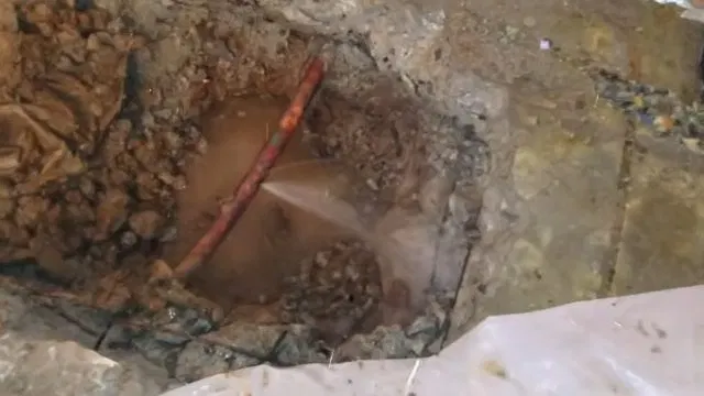 Excavated Indoor Floor Revealing Water Line shown for Water Bill Spike in Dallas, GA: Is It a Leak? in Dallas, Georgia.