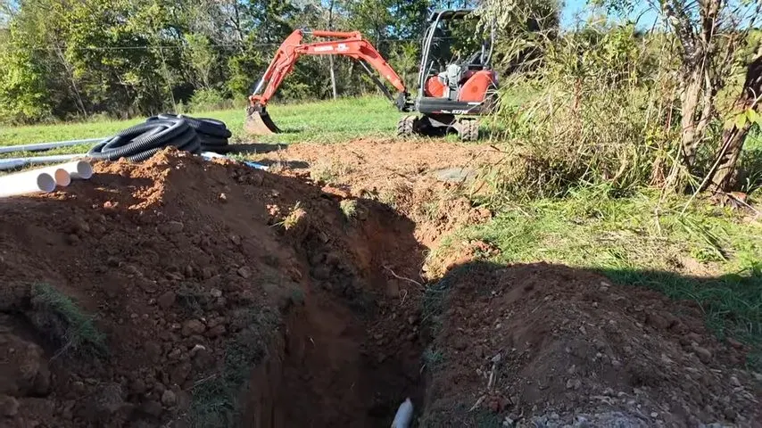 Excavator Opening Trench For Septic Pipe shown for Septic Tank Service in Dallas, GA in Dallas, Georgia.
