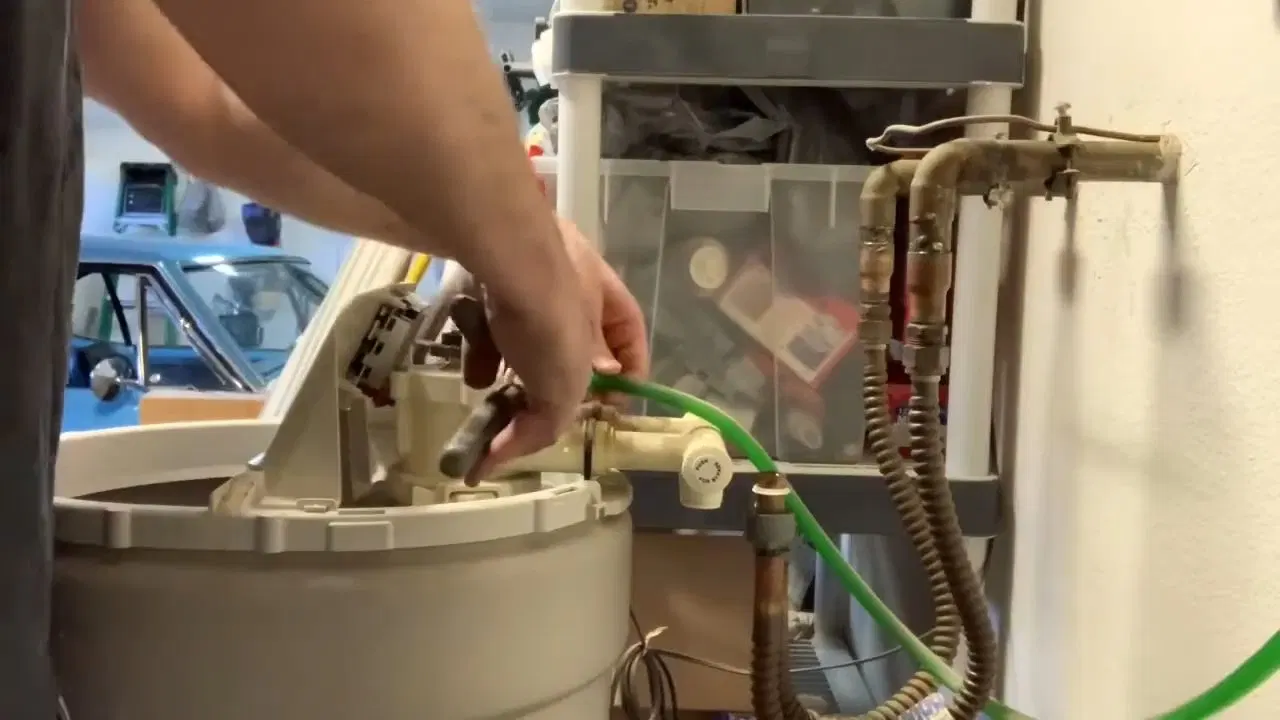 Hand Removing Water Softener Control Valve shown for Water Softener Installation & Repair in Dallas, GA in Dallas, Georgia.