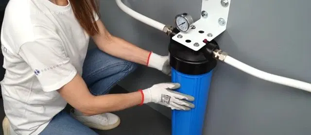Installing Blue Filter Canister Under Bracket shown for Is Dallas, GA's Water Actually Hard Enough to Need a Softener? in Dallas, Georgia.