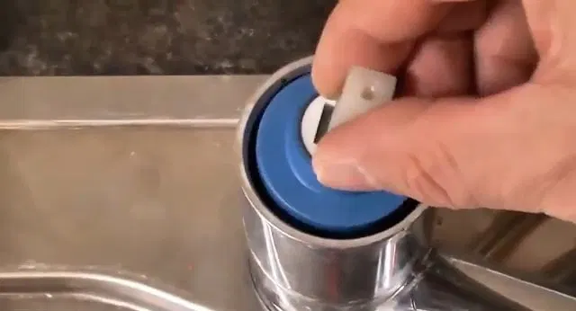 Lifting Cartridge Cap From Kitchen Faucet shown for Plumber in Dallas, GA in Dallas, Georgia.