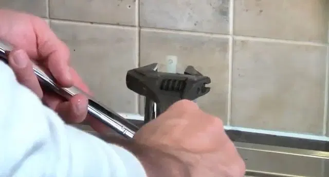 Loosening Kitchen Faucet Handle With Wrench shown for Plumber in Dallas, GA in Dallas, Georgia.