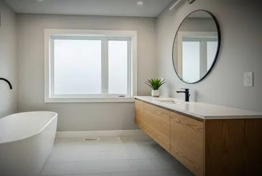 Modern Bathroom Remodel With Tub And Wood Vanity shown for How Long Should a Water Heater Actually Last in Dallas, GA? in Dallas, Georgia.