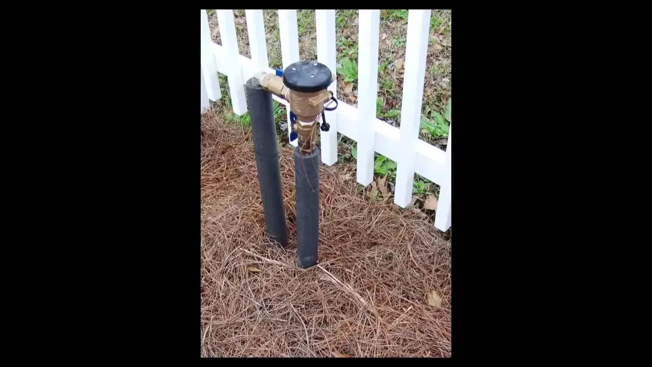 Residential Backflow Preventer Beside Fence shown for Plumber in Hiram, GA in Hiram, Georgia.