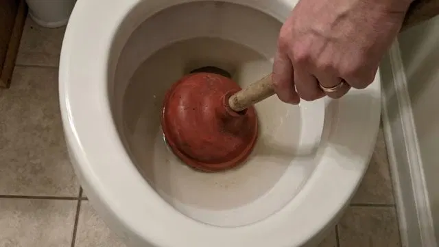 Scrubbing Debris From Floor Drain shown for Why Does Our Drain Keep Clogging Again After It's Been Snaked? in Dallas, Georgia.