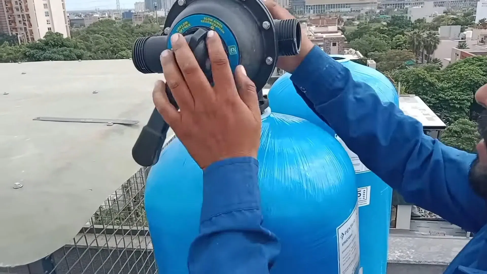 Technician Carrying Blue Water Softener Unit shown for Water Softener Installation & Repair in Dallas, GA in Dallas, Georgia.