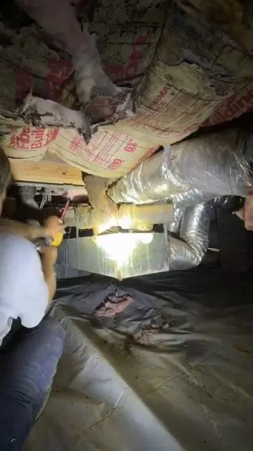 Technician Crawling Beneath House To Remove Drain shown for Why Does Our Drain Keep Clogging Again After It's Been Snaked? in Dallas, Georgia.