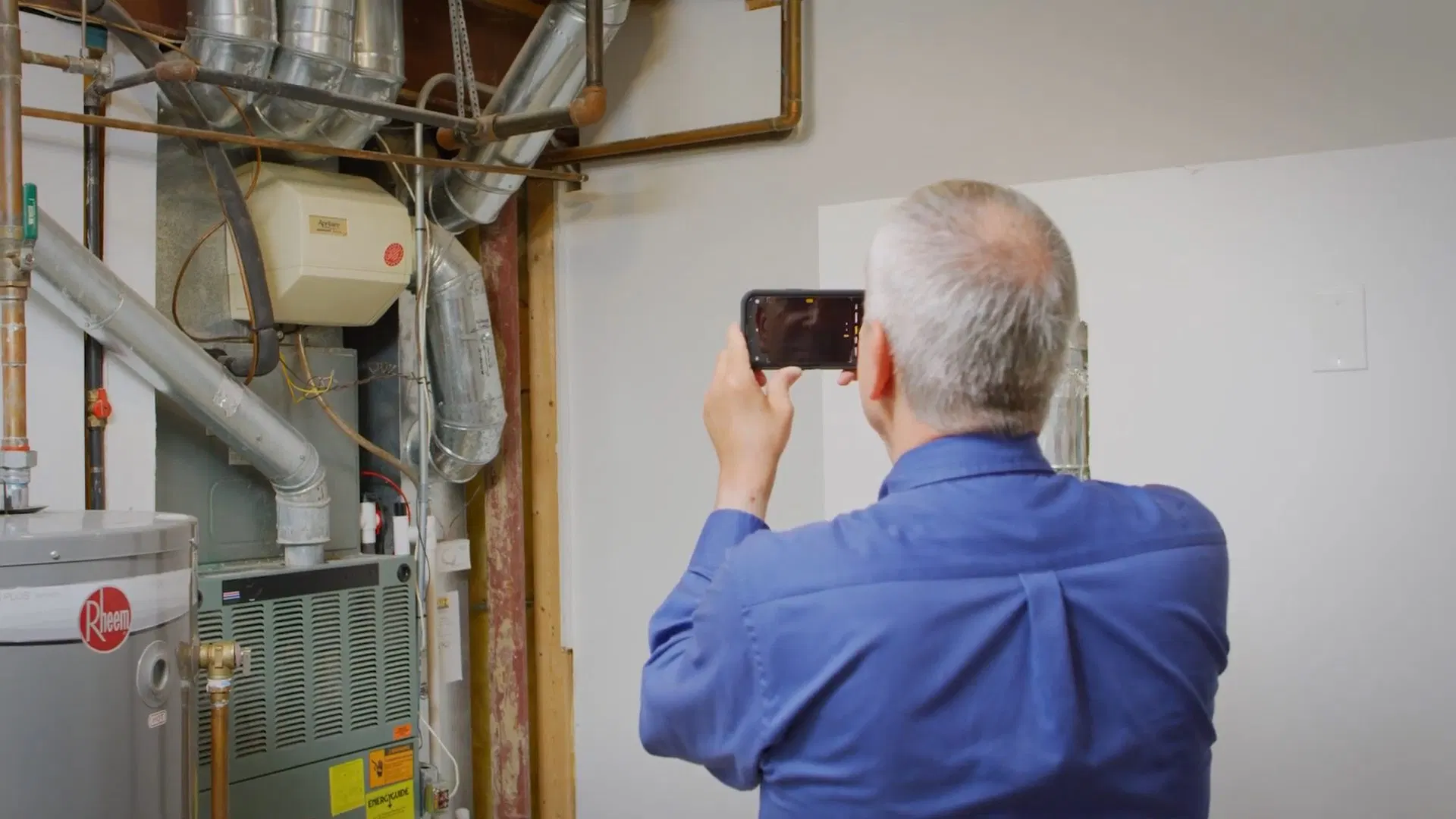 Technician Inspecting Existing Water Heater shown for Tankless Water Heater in Dallas, GA in Dallas, Georgia.