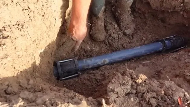 Tightening Repair Coupling In Excavation shown for Water Heater Repair in Dallas, GA in Dallas, Georgia.