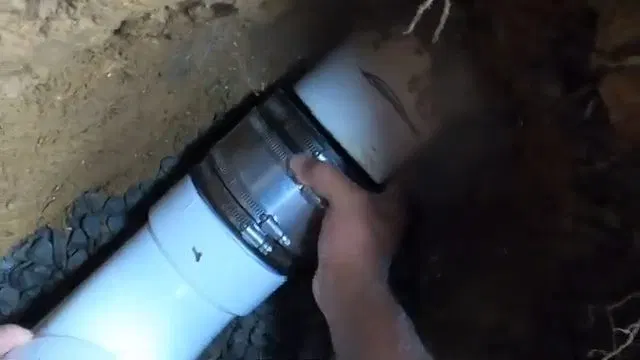 Tightening Rubber Coupling On Sewer Line shown for Sewer Line Repair & Replacement in Dallas, GA in Dallas, Georgia.