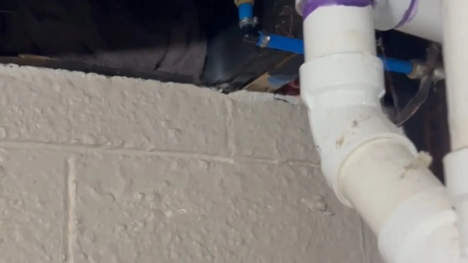 White PVC Drain Elbow On Brick Wall shown for Septic Tank Service in Dallas, GA in Dallas, Georgia.