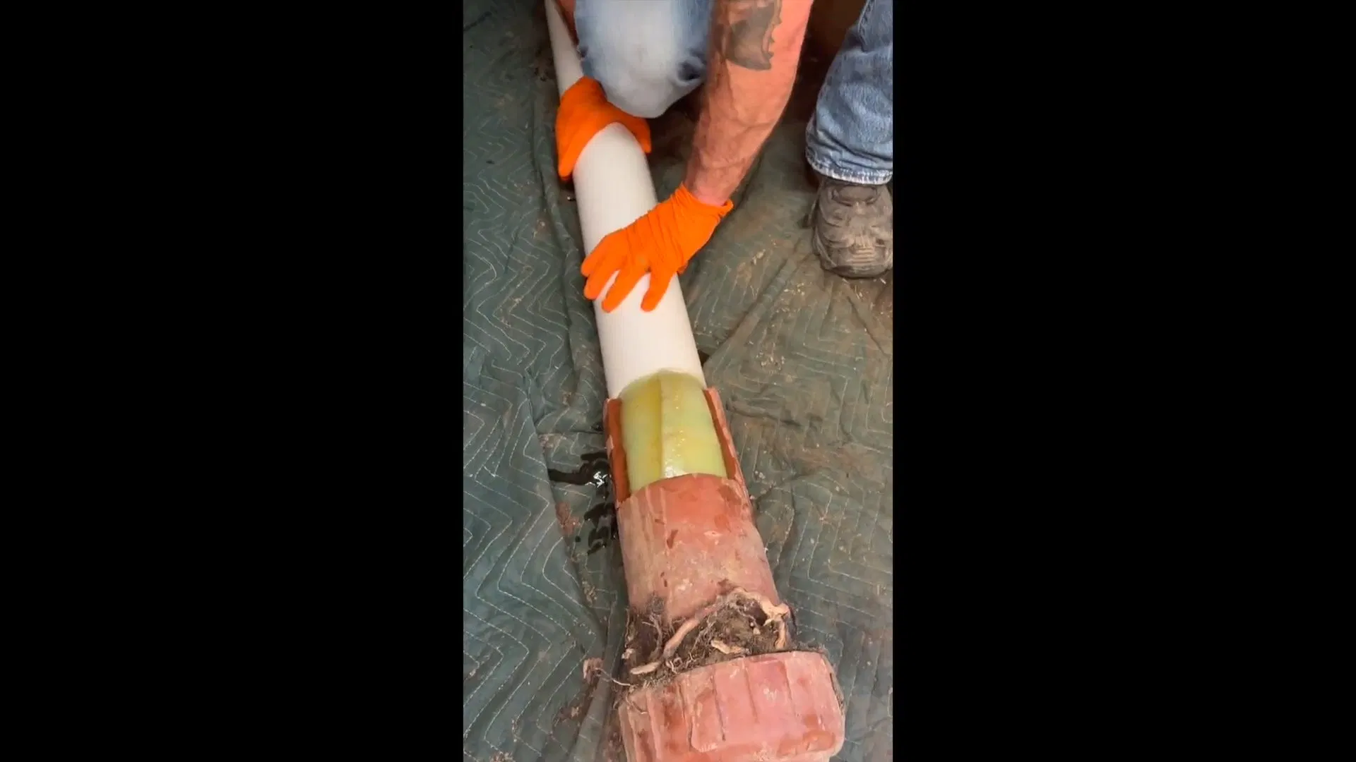 Worker Feeding Orange Sewer Lining Tube shown for Septic Tank Service in Dallas, GA in Dallas, Georgia.
