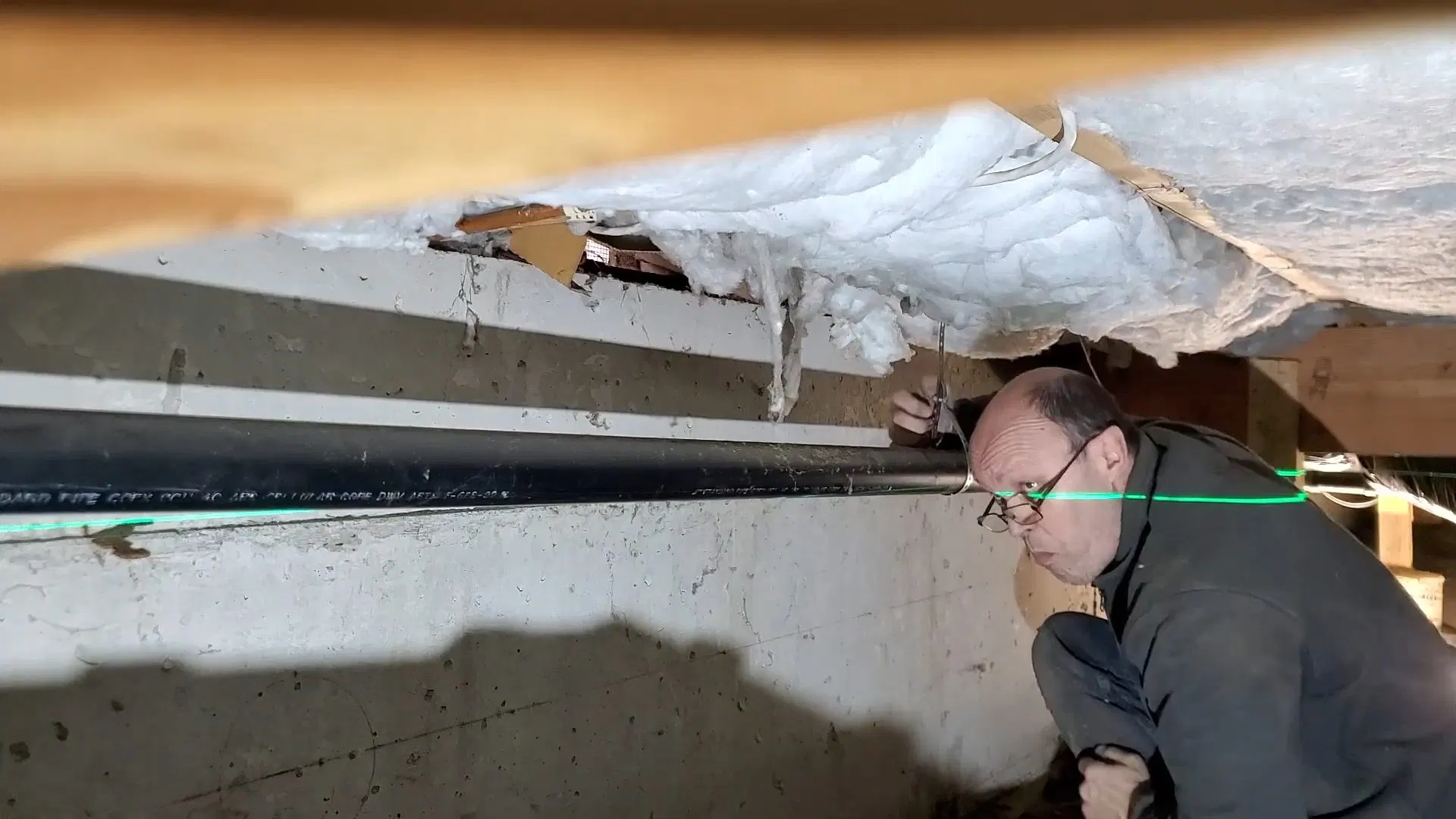 Worker Inspecting Crawlspace Pipe From Outside shown for Repiping in Dallas, GA in Dallas, Georgia.