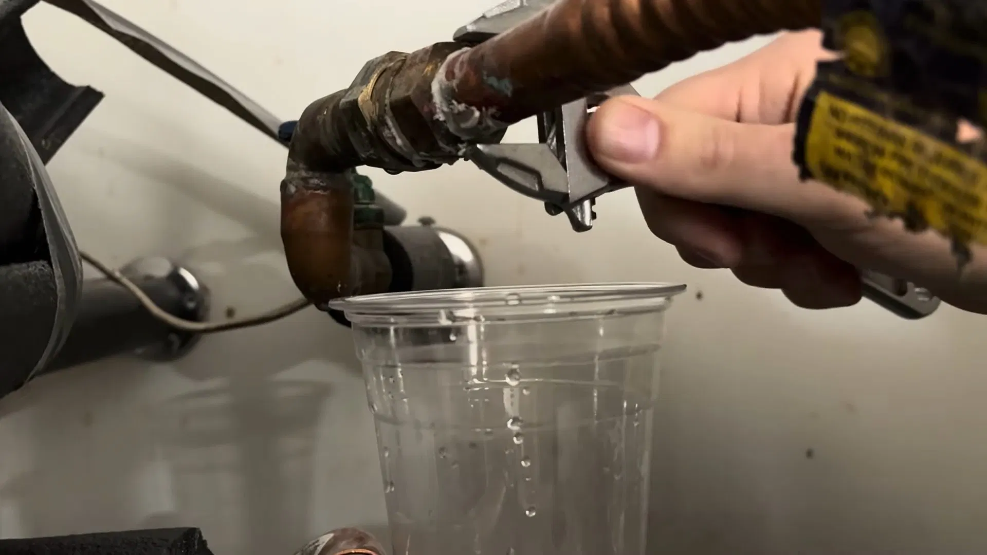 Worker Loosening Water Heater Inlet Fitting shown for Gas Line Installation & Repair in Dallas, GA in Dallas, Georgia.