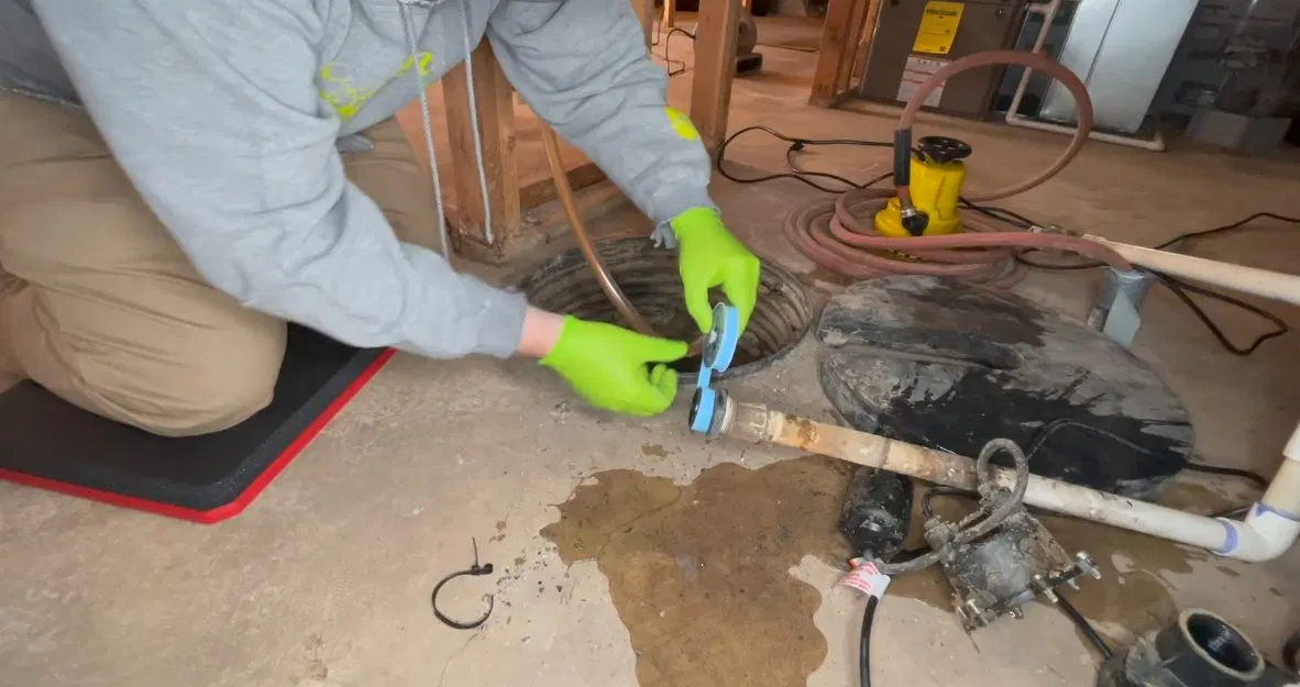 Worker Replacing Sump Pump In Basin shown for Areas we serve near Dallas, GA in Dallas, Georgia.
